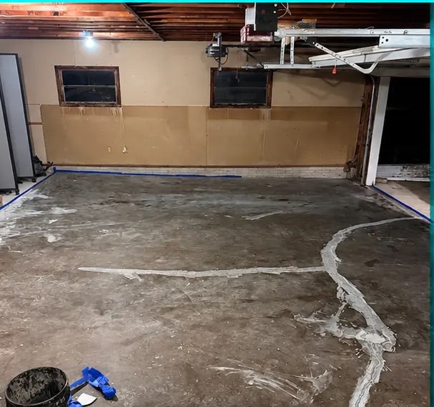Cracked, bare concrete garage floor before epoxy installation